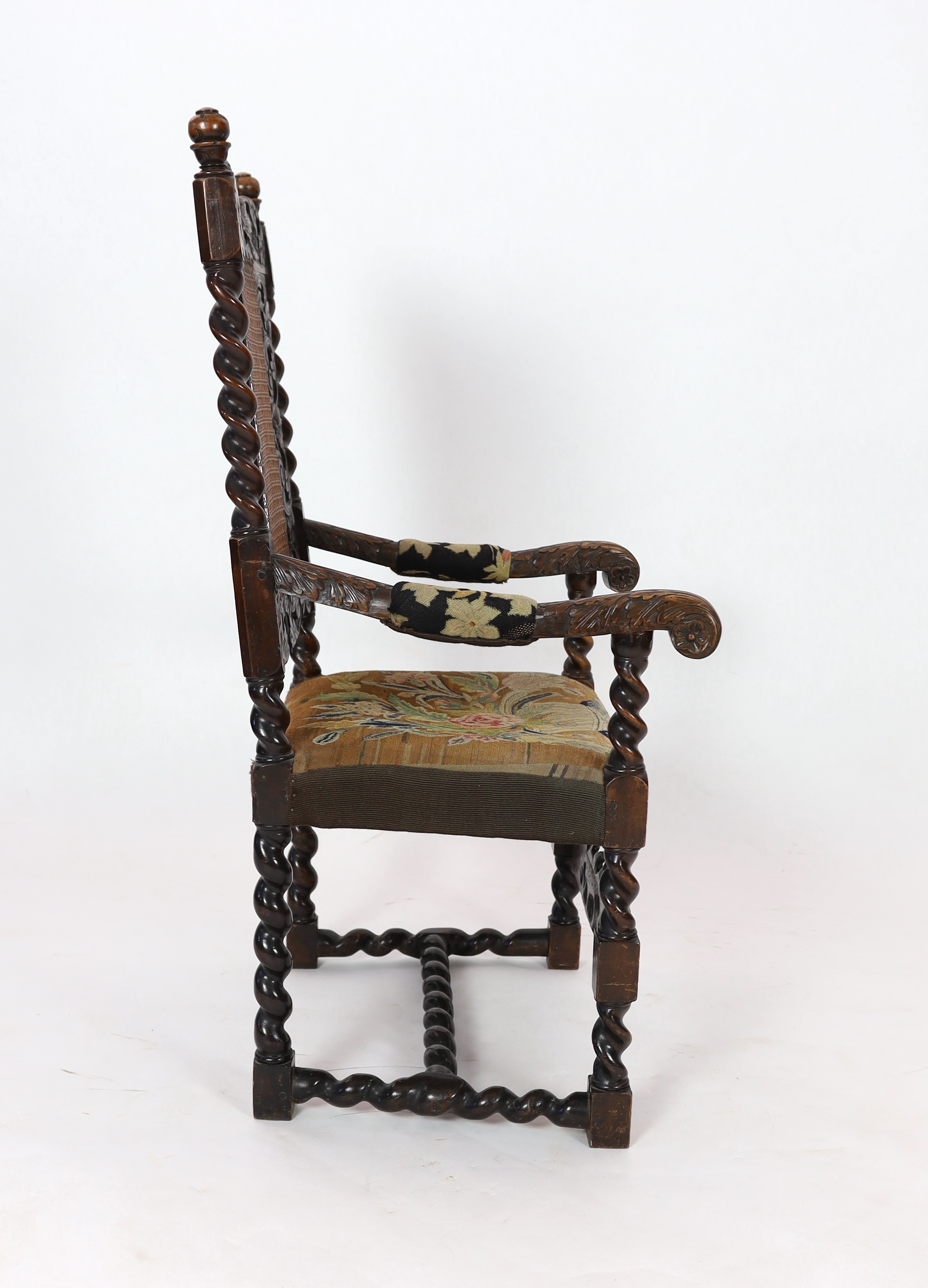 A Charles II carved walnut caned back elbow chair, with a contemporary needlework upholstered seat, c.1670, width 63cm, height 116cm, Please note this lot attracts an additional import tax of 5% on the hammer price